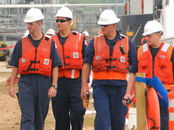 Four members of Patriot Environmental Services’ National Response team overseeing a waste project