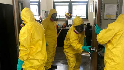 Four members of Patriot Environmental Services’ COVID-19 decontamination response team decontaminate an office building