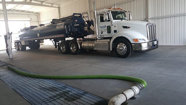 A Patriot Environmental Services vacuum tanker unloads waste and one of the company’s wastewater treatment facilities