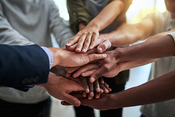 A diverse group of Patriot Environmental Services employees join their hands together