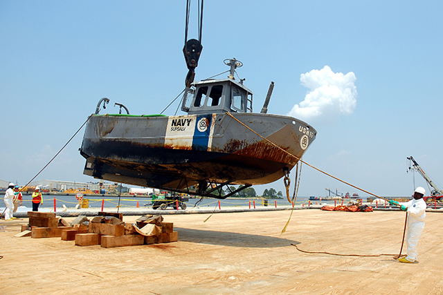 Patriot Environmental Services crews recovery a sunken U.S. Navy vessel from the harbor