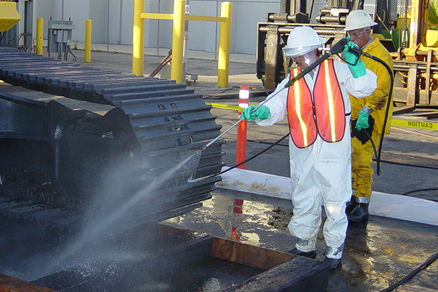 A Patriot Environmental Services technician hydro blasts a piece of mining equipment