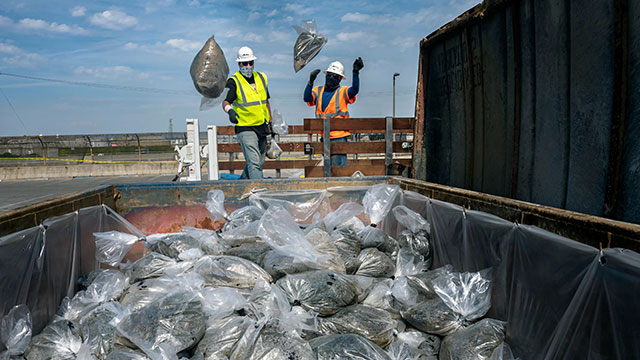 Patriot employees cleaning up oil on a beach